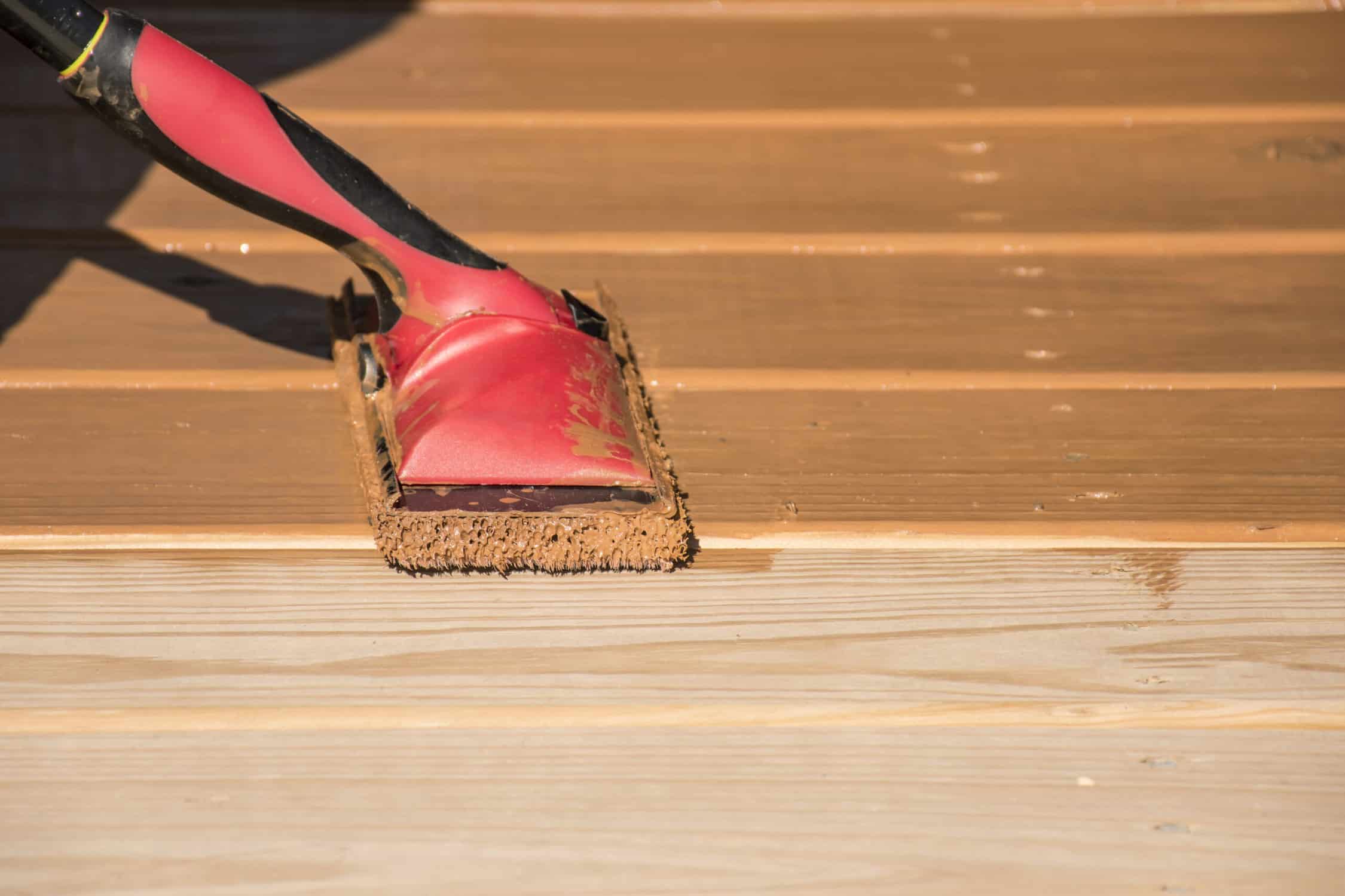 deck painting problems - Staining a wooden deck with a staining pad.
